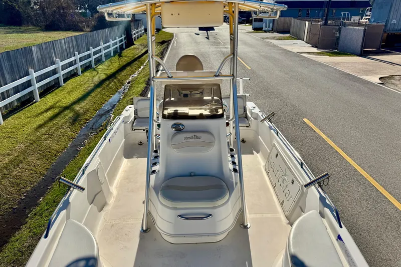 Slide: The Image of 2006 NauticStar 2200 NauticBay boat with T-top, parked on a sunny street. - 14