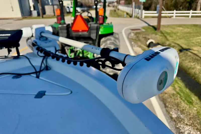 Slide: The Image of 2006 NauticStar 2200 NauticBay boat with trolling motor, parked near a green tractor. - 17