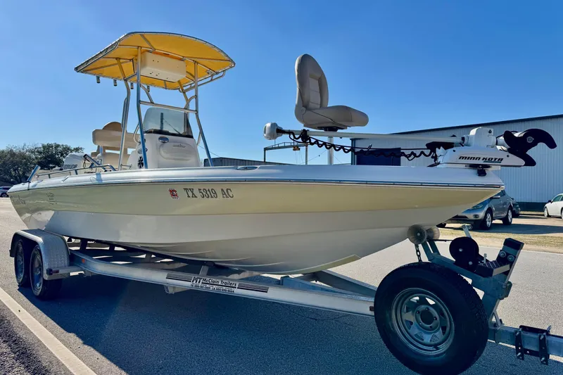Slide: The Image of 2006 NauticStar 2200 NauticBay boat on trailer with yellow canopy, parked outdoors. - 4