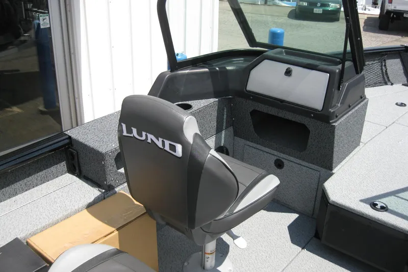 Slide: The Image of 2025 Lund 1875 Impact XS Sport boat interior with seating and storage compartments. - 10