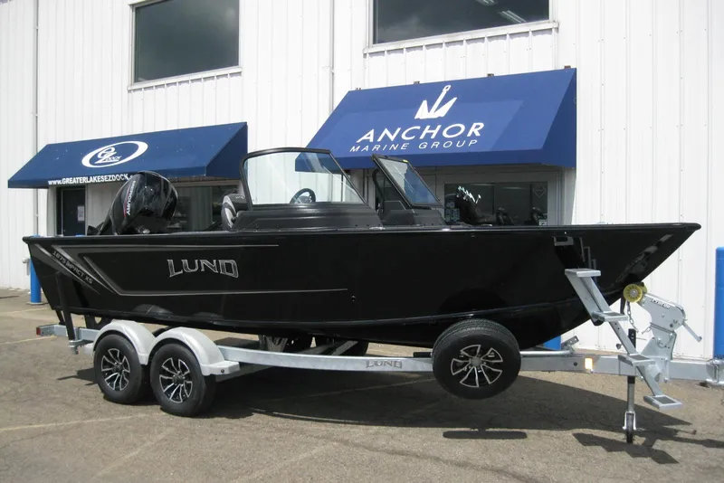 Slide: The Image of 2025 Lund 1875 Impact XS Sport boat on trailer outside Anchor Marine Group. - 2