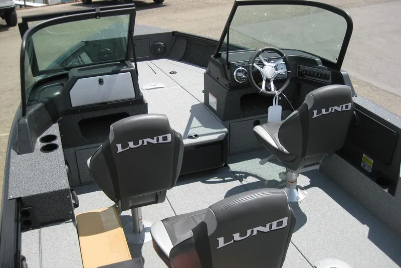 Slide: The Image of 2025 Lund 1875 Impact XS Sport boat interior with steering wheel and seating. - 6