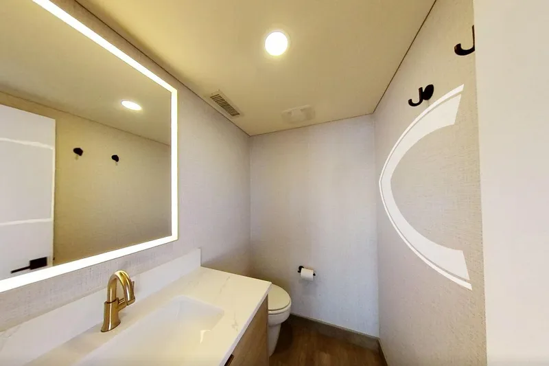 Slide: The Image of Modern bathroom with illuminated mirror, gold faucet, and minimalist design. Adonia Radiance Share #3, 2022. - 28