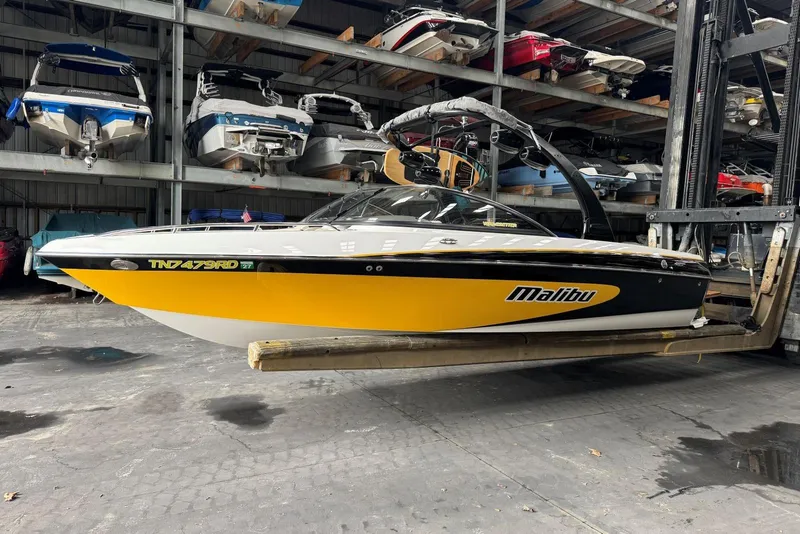 Slide: The Image of 2005 Malibu Wakesetter VLX boat in storage, yellow and black design. - 1