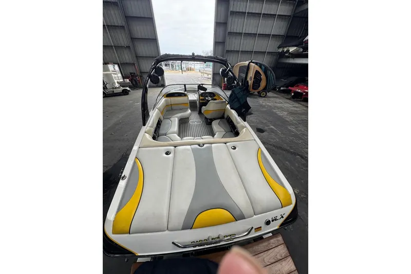 Slide: The Image of 2005 Malibu Wakesetter VLX boat interior with yellow and gray seating in a storage facility. - 10