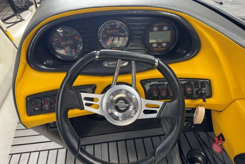 Slide: The Image of Dashboard of a 2005 Malibu Wakesetter VLX boat with steering wheel and gauges. - 14