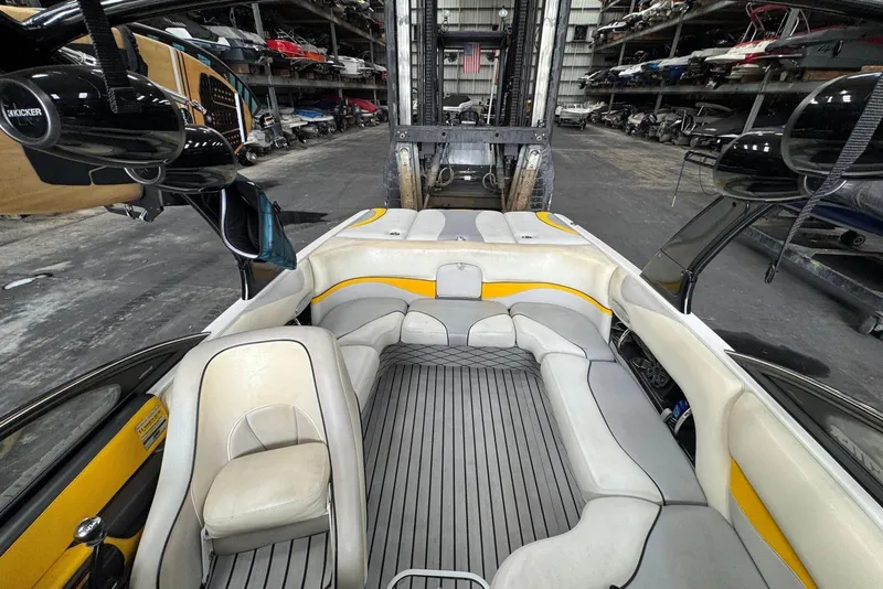 Slide: The Image of 2005 Malibu Wakesetter VLX interior with gray and yellow seating in a storage facility. - 21