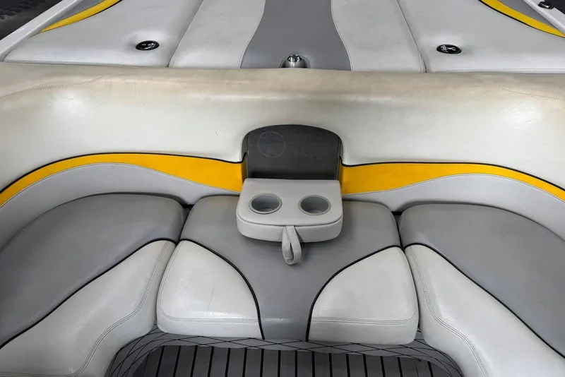 Slide: The Image of 2005 Malibu Wakesetter VLX boat interior with gray and yellow seating, featuring cup holders. - 23