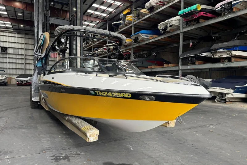 Slide: The Image of 2005 Malibu Wakesetter VLX boat in storage, yellow and white exterior, indoor facility. - 3