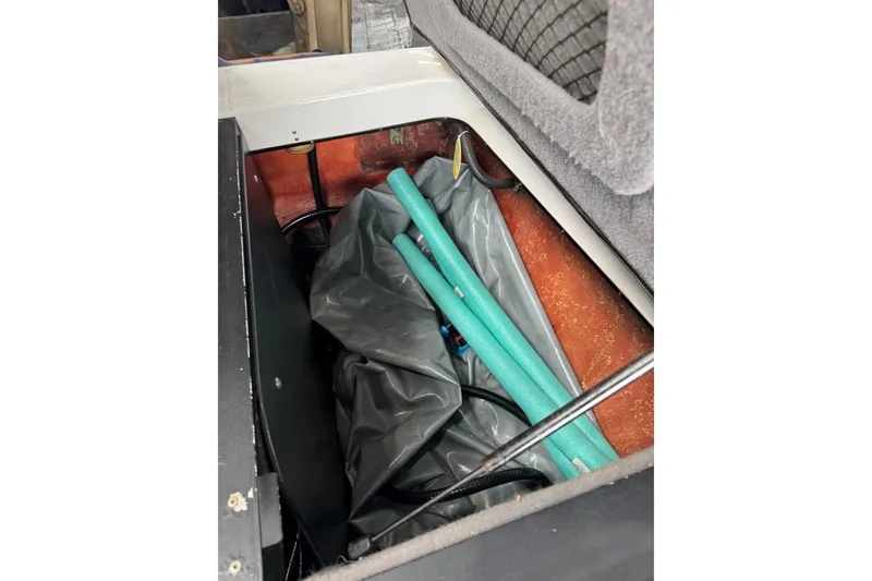 Slide: The Image of 2005 Malibu Wakesetter VLX storage compartment with pool noodles and equipment. - 31