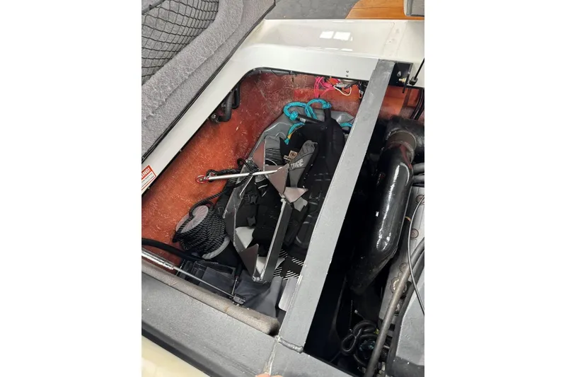 Slide: The Image of 2005 Malibu Wakesetter VLX engine compartment with visible components and storage items. - 33