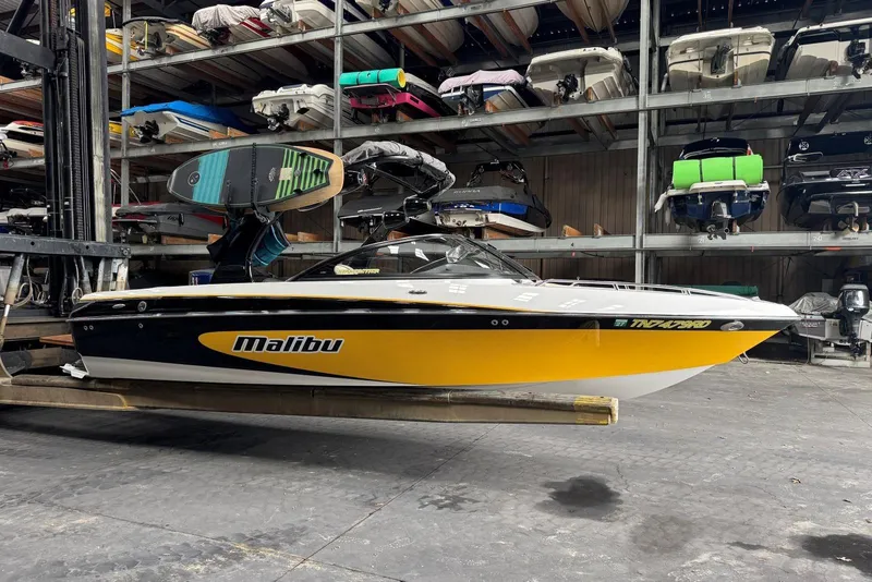 Slide: The Image of 2005 Malibu Wakesetter VLX boat in storage, featuring a vibrant yellow and black design. - 5