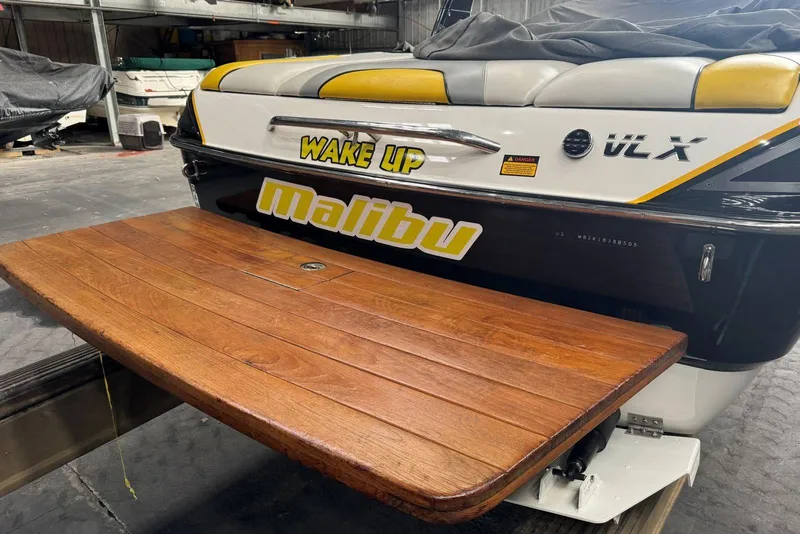 Slide: The Image of 2005 Malibu Wakesetter VLX boat with wooden swim platform in a storage facility. - 9