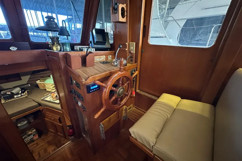 Slide: The Image of 1986 Present Yachts 35 MotorYacht helm with wooden wheel and cozy seating. - 10