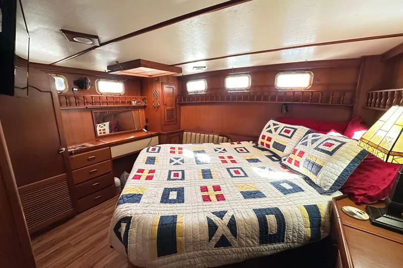 Slide: The Image of Cozy cabin interior of 1986 Present Yachts 35 MotorYacht with nautical-themed bedding. - 18