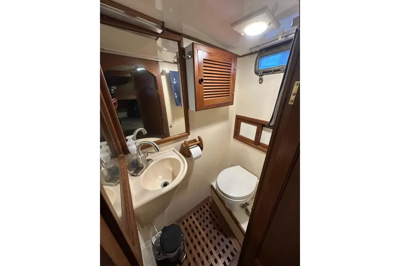 Slide: The Image of 1986 Present Yachts 35 MotorYacht bathroom with sink, toilet, and wooden accents. - 27