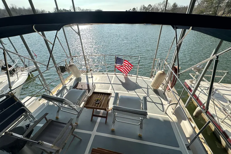 Slide: The Image of 1986 Present Yachts 35 MotorYacht deck with chairs, table, and American flag on water. - 33