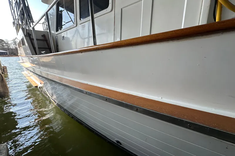 Slide: The Image of 1986 Present Yachts 35 MotorYacht with white hull and wooden trim docked on water. - 6