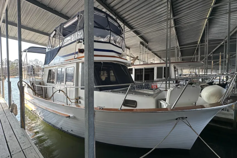 Slide: The Image of 1986 Present Yachts 35 MotorYacht docked under a covered marina. - 1