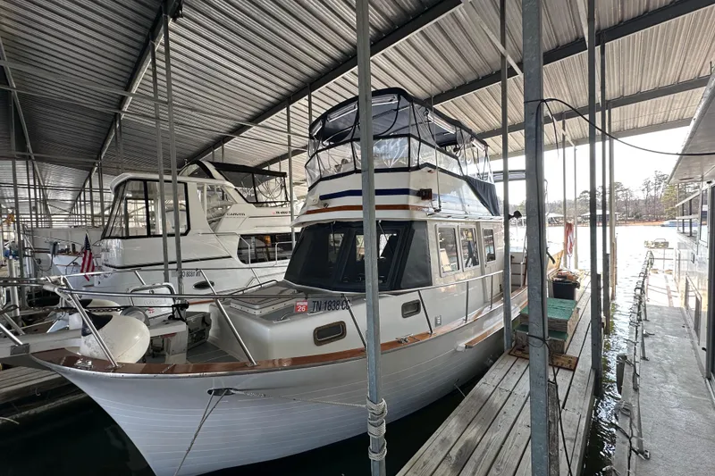 Slide: The Image of 1986 Present Yachts 35 MotorYacht docked in a covered marina. - 2