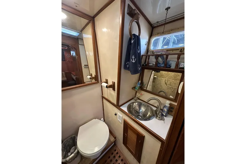 Slide: The Image of 1986 Present Yachts 35 MotorYacht bathroom with sink, toilet, and nautical decor. - 26
