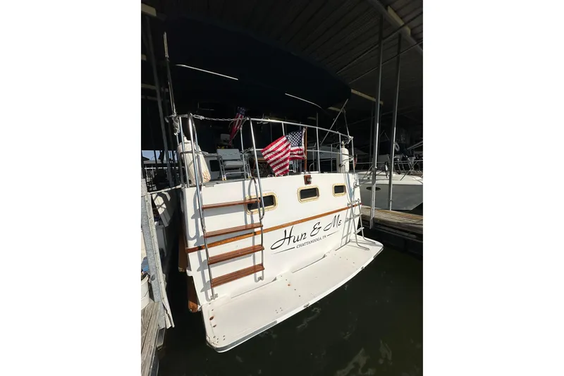 Slide: The Image of 1986 Present Yachts 35 MotorYacht docked, rear view with American flag. - 7