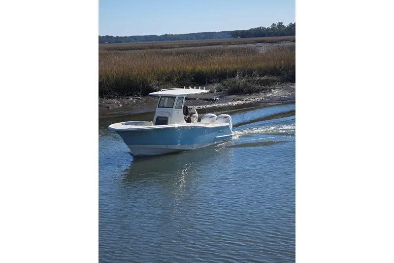 Slide: The Image of 2026 Pioneer boat cruising on a calm river with marshland background. - 2