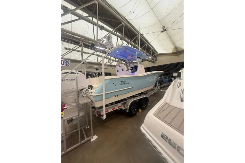Slide: The Image of 2026 Pioneer 250 Pelagic boat displayed indoors on a trailer. - 8