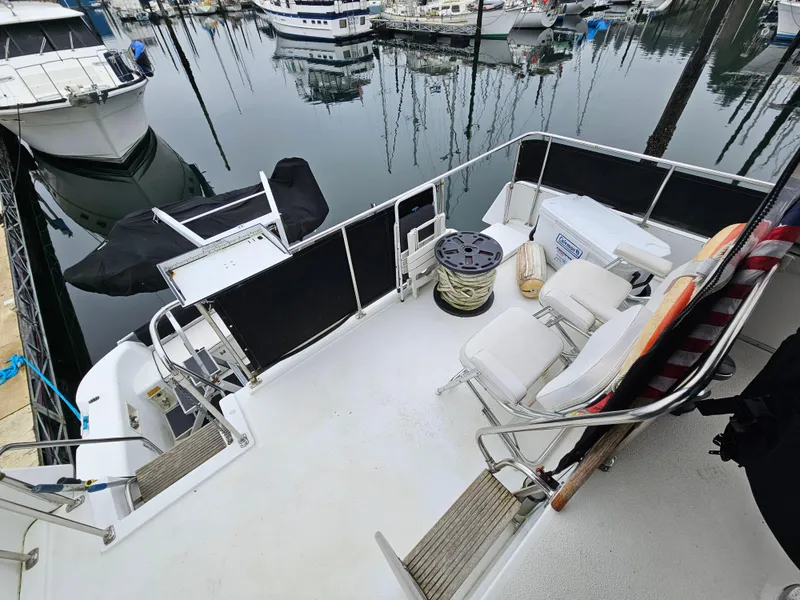 Slide: The Image of 1991 Tollycraft Euro Sport Sedan boat deck with seating, docked in a marina. - 14