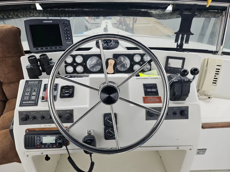 Slide: The Image of 1991 Tollycraft Euro Sport Sedan helm with steering wheel, gauges, and navigation equipment. - 21