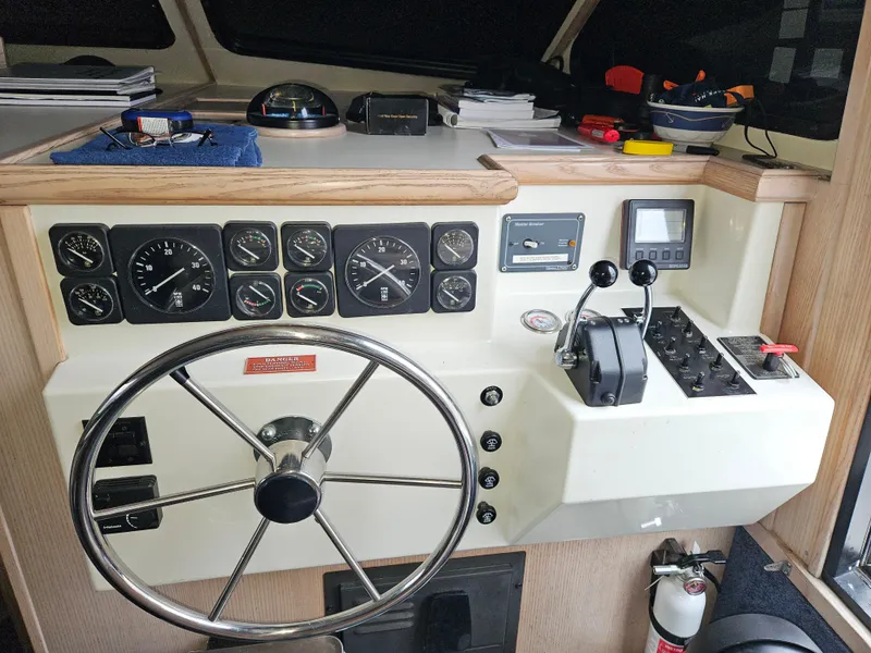 Slide: The Image of 1991 Tollycraft Euro Sport Sedan helm with gauges, steering wheel, and control panel. - 24