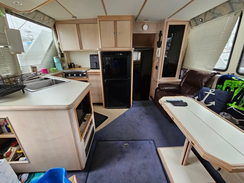 Slide: The Image of Interior of a 1991 Tollycraft Euro Sport Sedan, featuring a kitchen and seating area. - 27