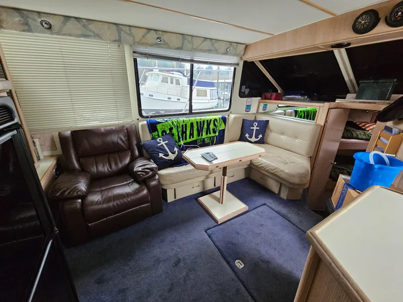 Slide: The Image of Interior of 1991 Tollycraft Euro Sport Sedan with seating, table, and nautical decor. - 30