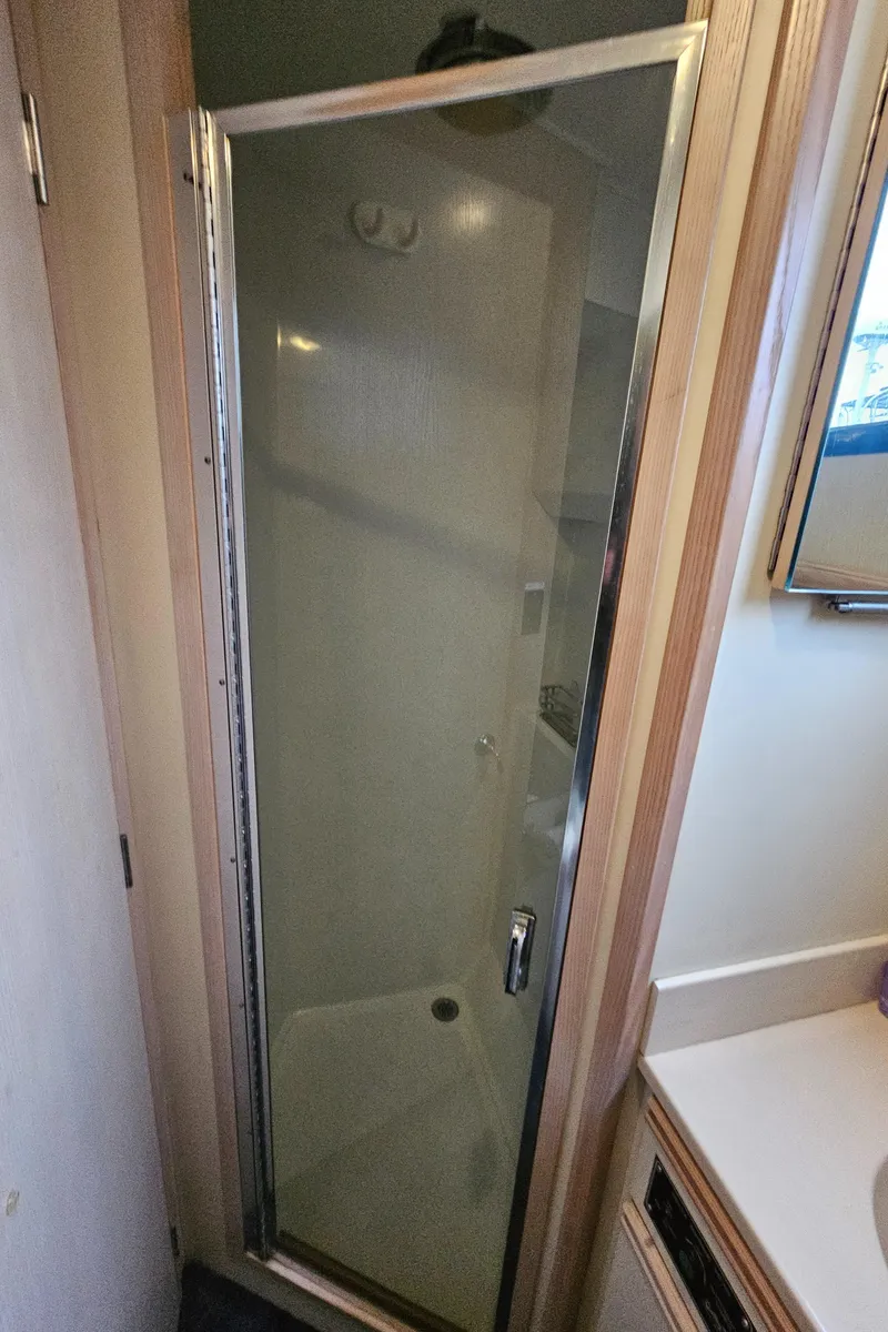 Slide: The Image of Shower area in 1991 Tollycraft Euro Sport Sedan boat, featuring a glass door. - 41