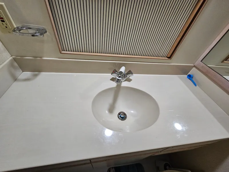 Slide: The Image of 1991 Tollycraft Euro Sport Sedan bathroom sink with modern faucet and countertop. - 45