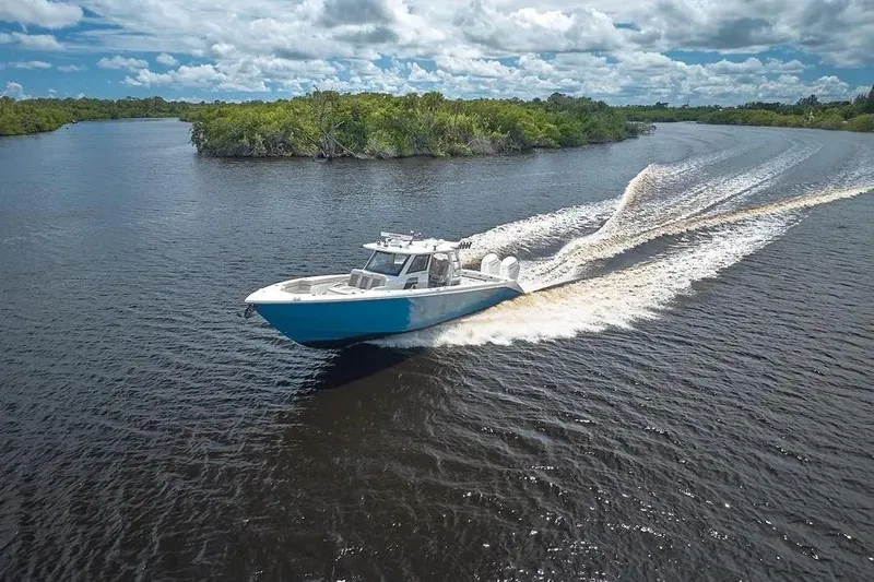 The Image of 2022 Solace 41 CS boat cruising on a scenic river under a cloudy sky. - 0