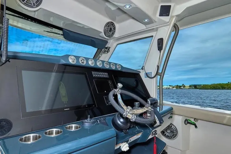Slide: The Image of Helm of 2022 Solace 41 CS boat with modern navigation equipment and scenic water view. - 16