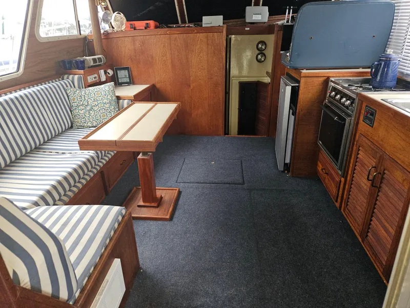 Slide: The Image of Interior of 1978 Tollycraft 37 Sport Sedan with striped seating and wooden cabinetry. - 10
