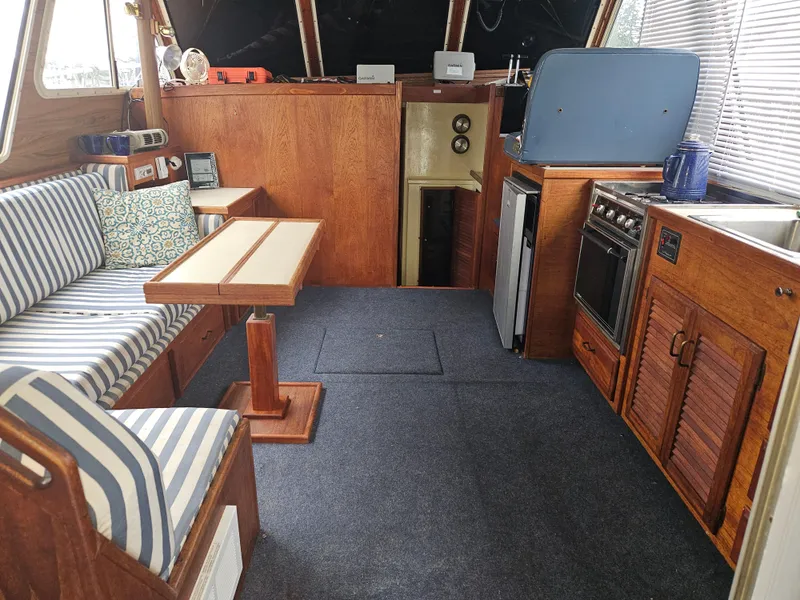 Slide: The Image of Interior of 1978 Tollycraft 37 Sport Sedan with striped seating and wooden cabinetry. - 7