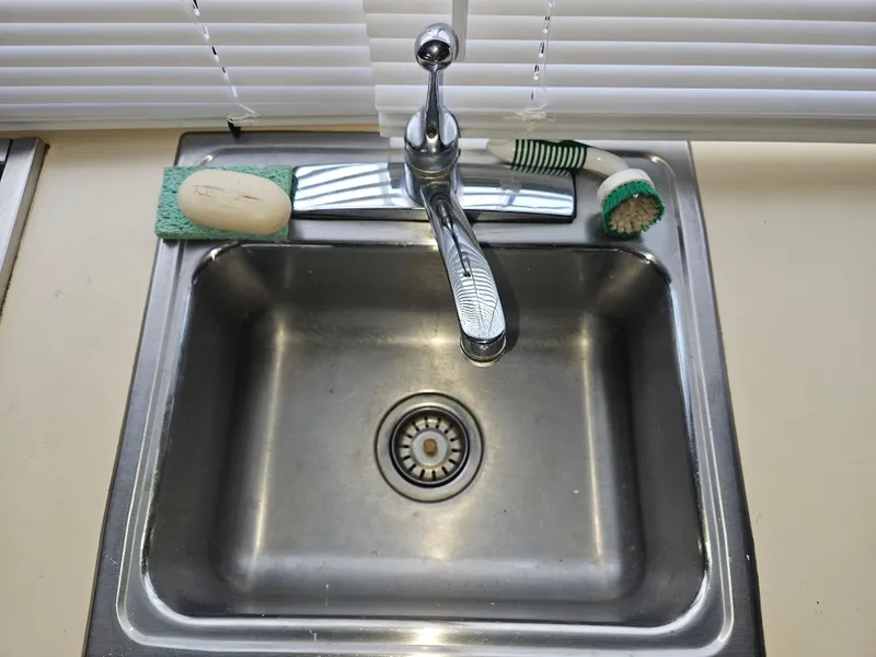 Slide: The Image of Stainless steel sink with faucet, soap, and brushes on a 1978 Tollycraft 37 Sport Sedan. - 13
