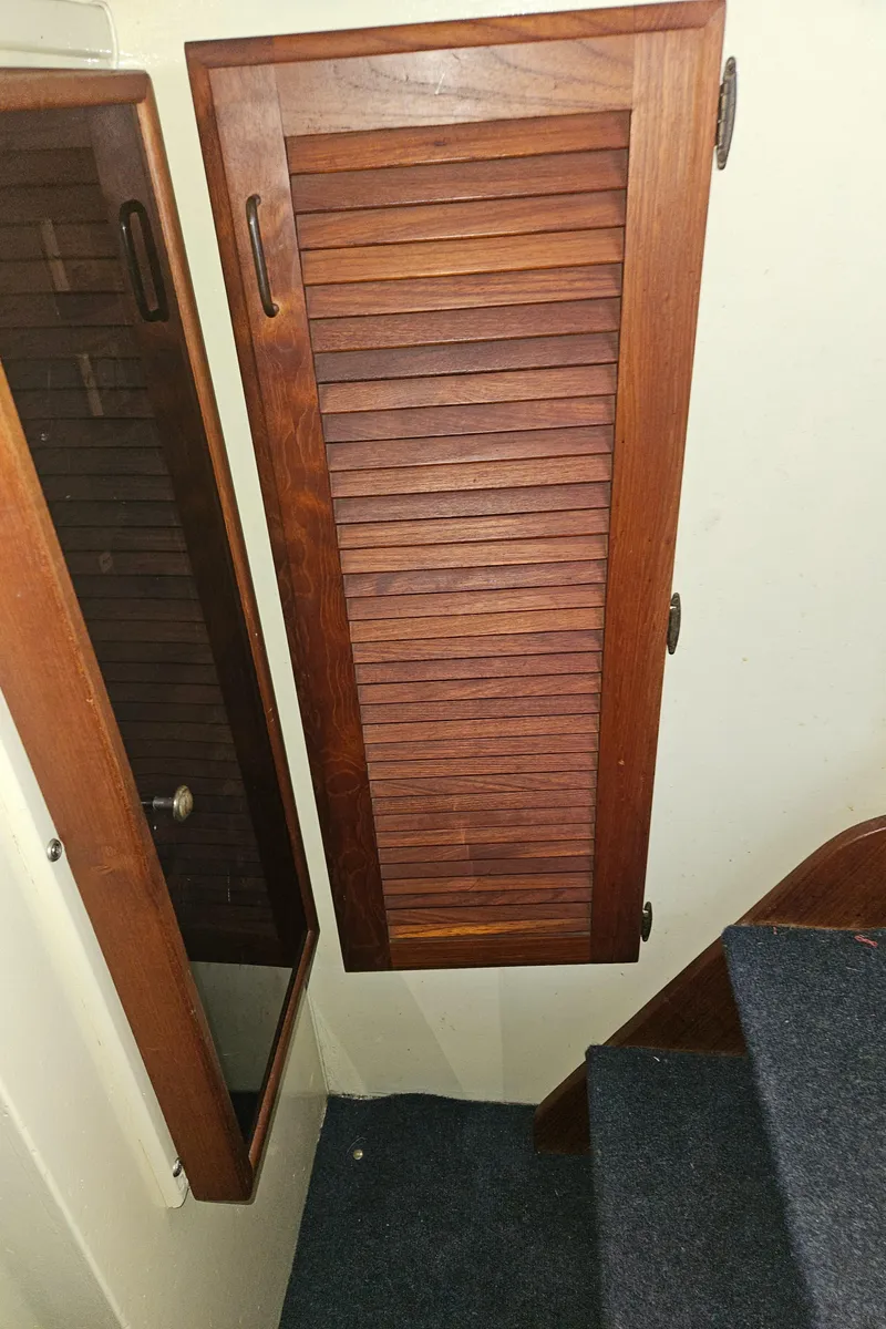Slide: The Image of 1978 Tollycraft 37 Sport Sedan interior with wooden louvered door and carpeted stairs. - 16
