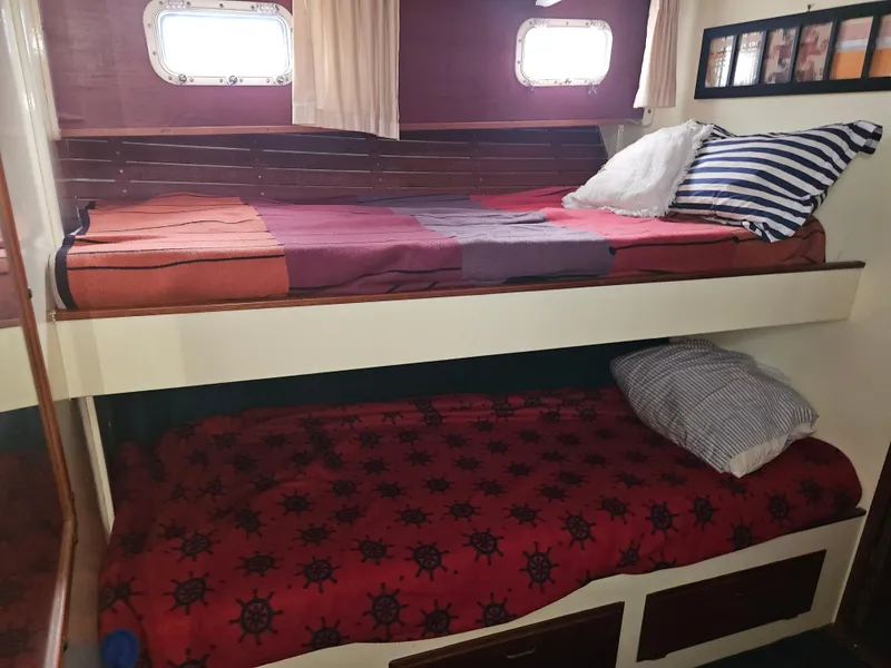 Slide: The Image of 1978 Tollycraft 37 Sport Sedan interior with bunk beds and nautical-themed bedding. - 21