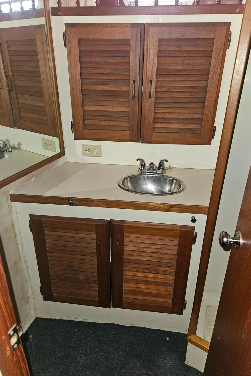 Slide: The Image of 1978 Tollycraft 37 Sport Sedan bathroom with wooden cabinets and stainless steel sink. - 25