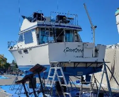 Slide: The Image of 1978 Tollycraft 37 Sport Sedan boat on dry dock with ladders and equipment. - 3
