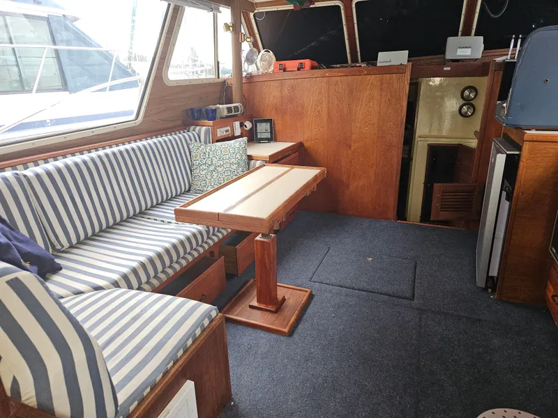 Slide: The Image of 1978 Tollycraft 37 Sport Sedan interior with striped seating and wooden table. - 6