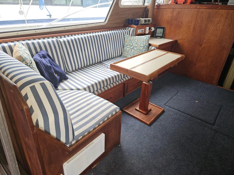 Slide: The Image of Interior of 1978 Tollycraft 37 Sport Sedan with striped seating and wooden table. - 9