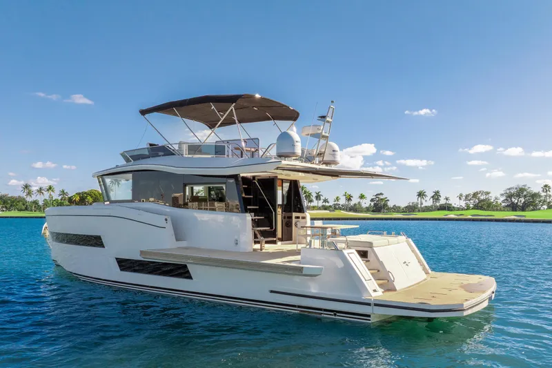 Slide: The Image of 2023 Pardo Yachts E60 on serene water, clear sky, and lush shoreline. - 15