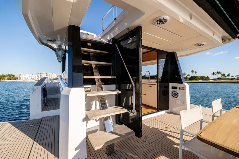 Slide: The Image of 2023 Pardo Yachts E60 deck with seating and table, overlooking serene water. - 23