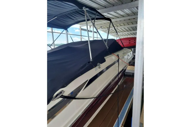 Slide: The Image of 2012 Sea Ray 240 Sundeck boat with cover, docked under shelter. - 37