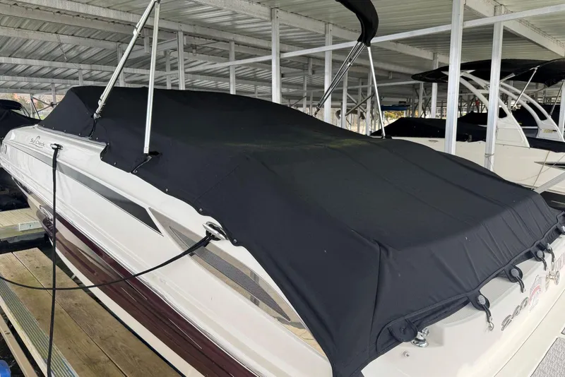 Slide: The Image of 2012 Sea Ray 240 Sundeck boat with black cover in marina storage. - 40